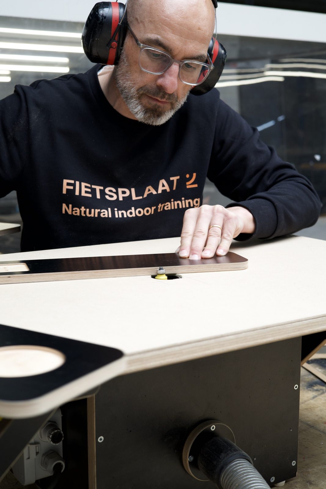 Een plaat wordt nagelopen aan de werkbank